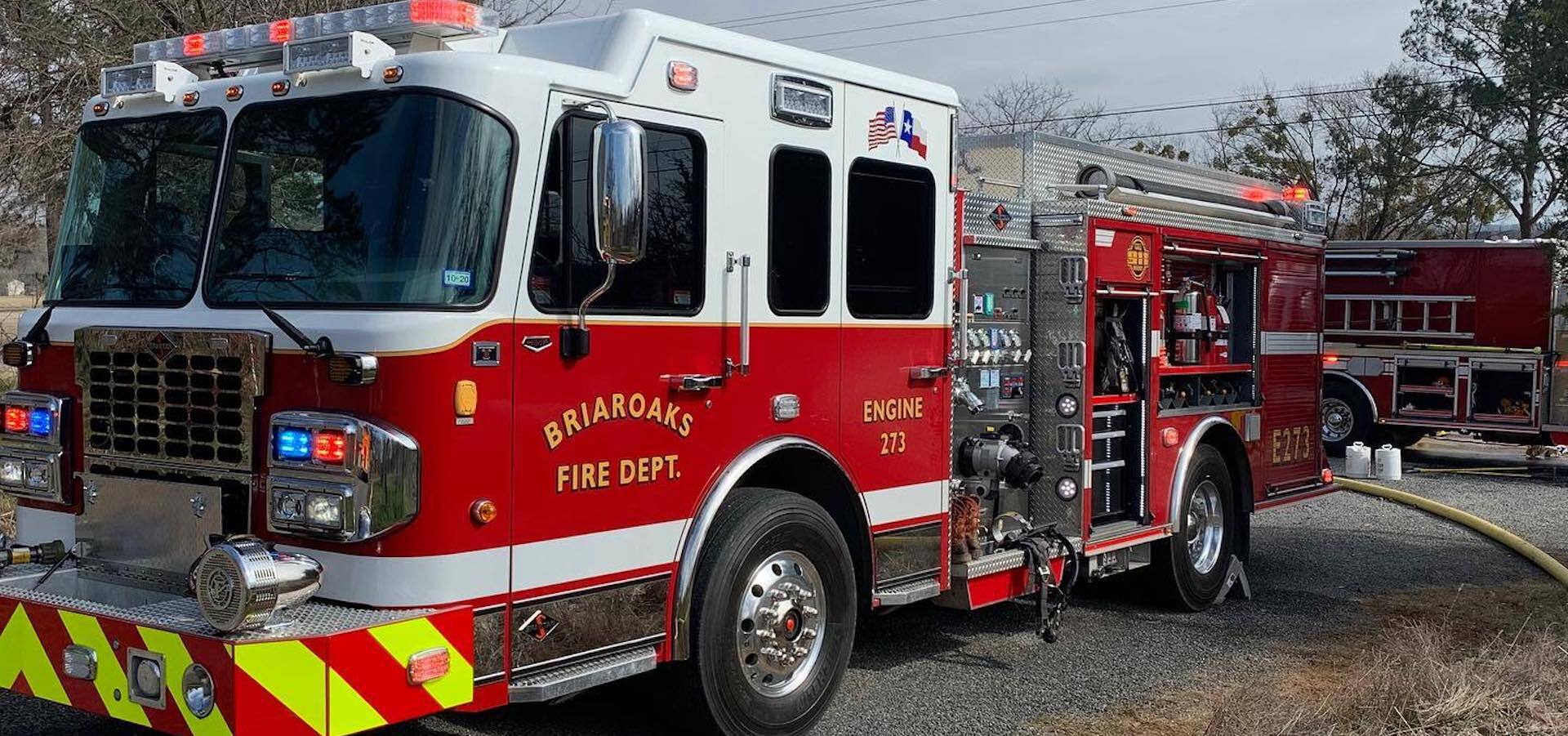 A Briaroaks fire truck is parked on a gravel road.