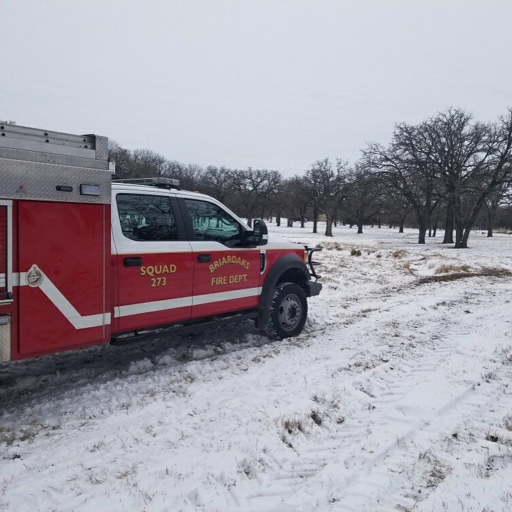 A red squad 273 truck is parked in the snow