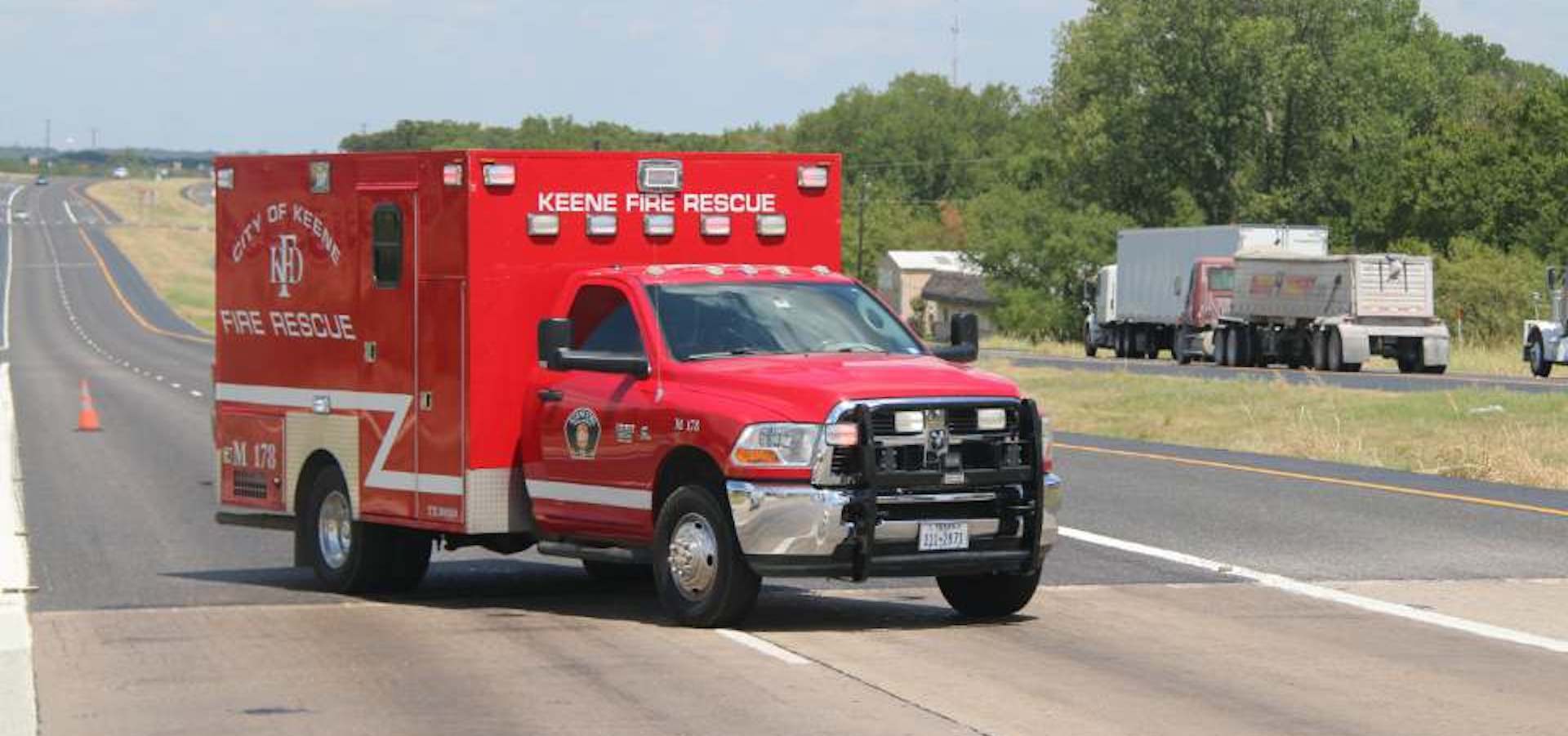 A Keene ambulance is parked on a highway