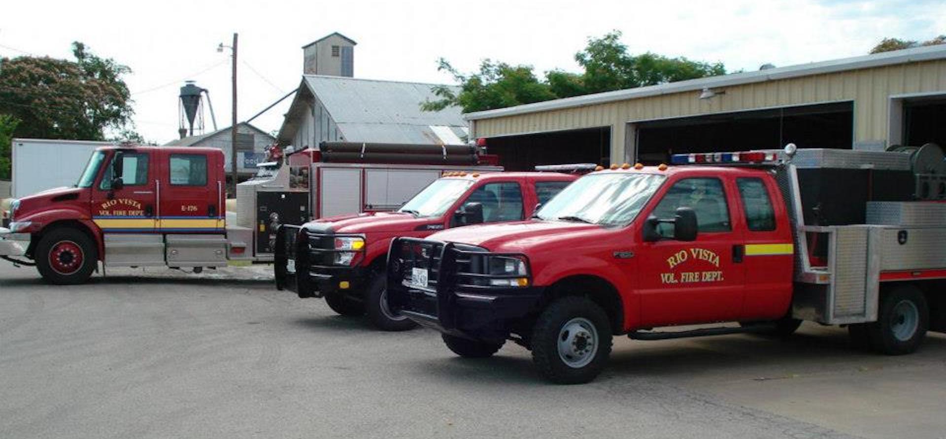 A row of Rio Vista fire trucks parked in front of a fire station.