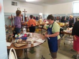 People serving food at a buffet table in a community hall