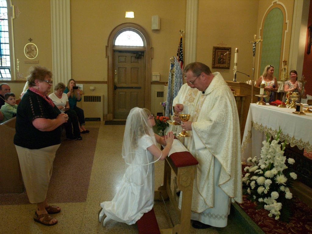 Bride kneeling before priest in a church during a wedding ceremony