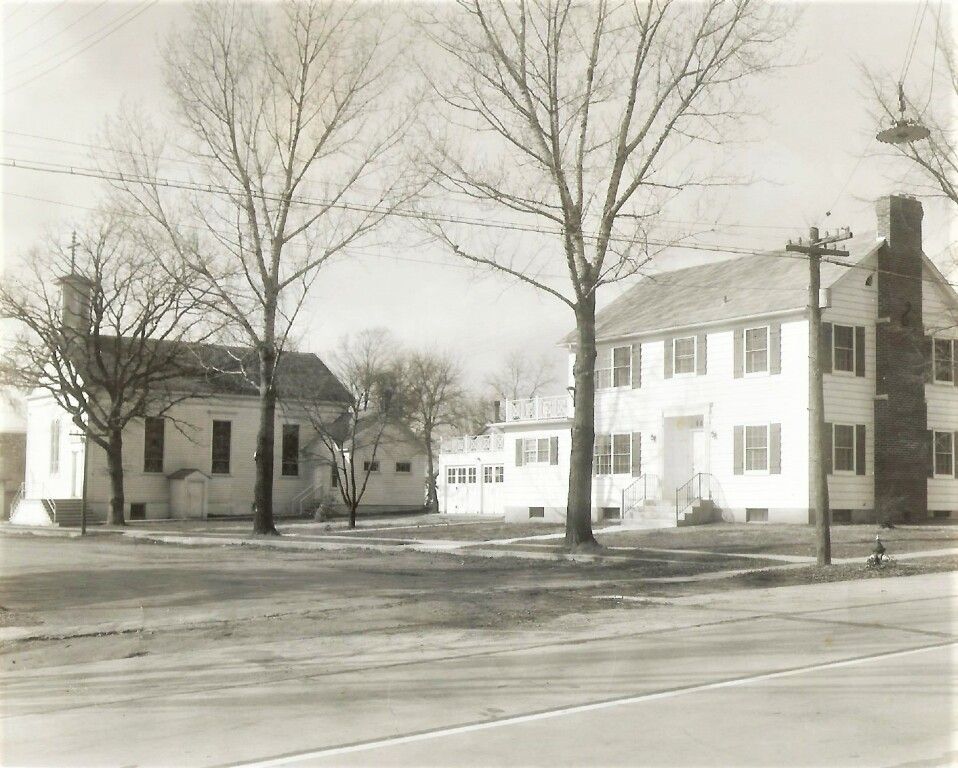 Quiet winter street with three houses and leafless trees along a road