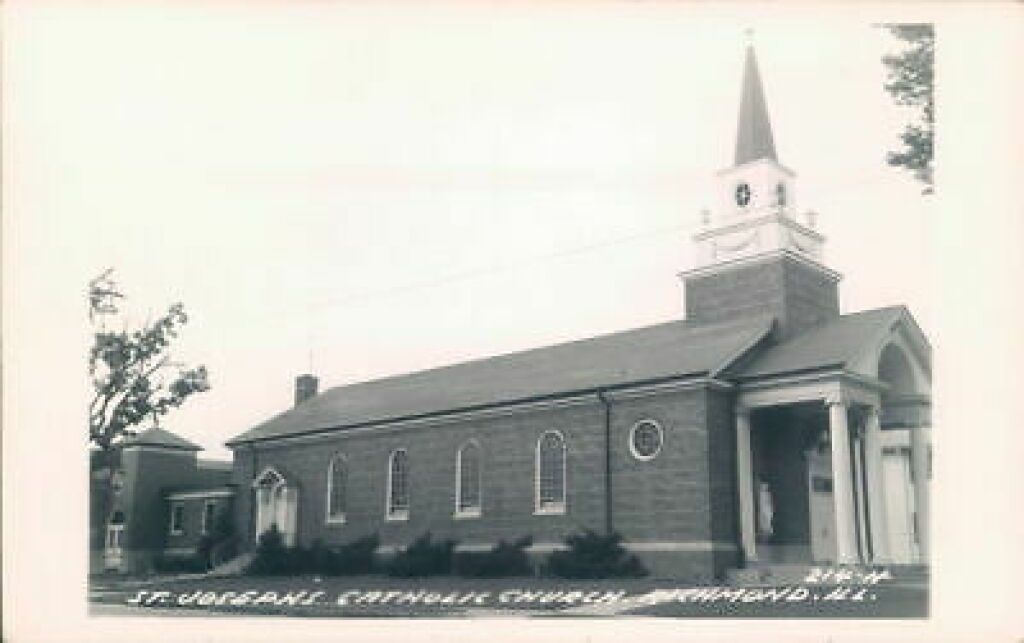 Black-and-white photo of a small church with steeple and front porch in a rural setting