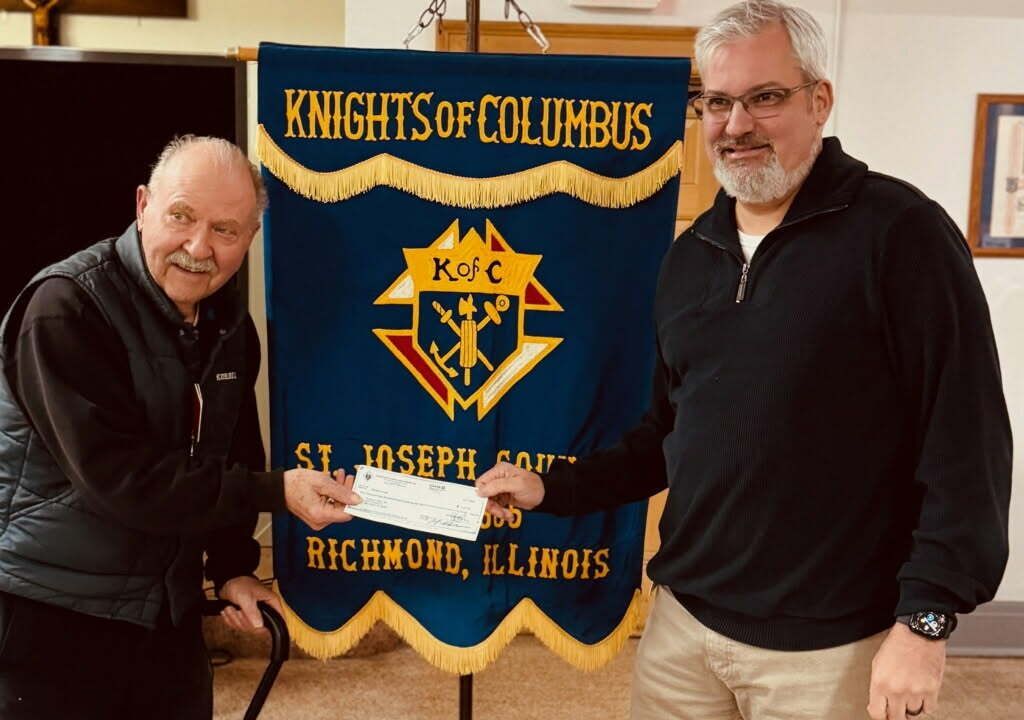 Two men holding a Knights of Columbus banner at St. Joseph, Richmond, Illinois.