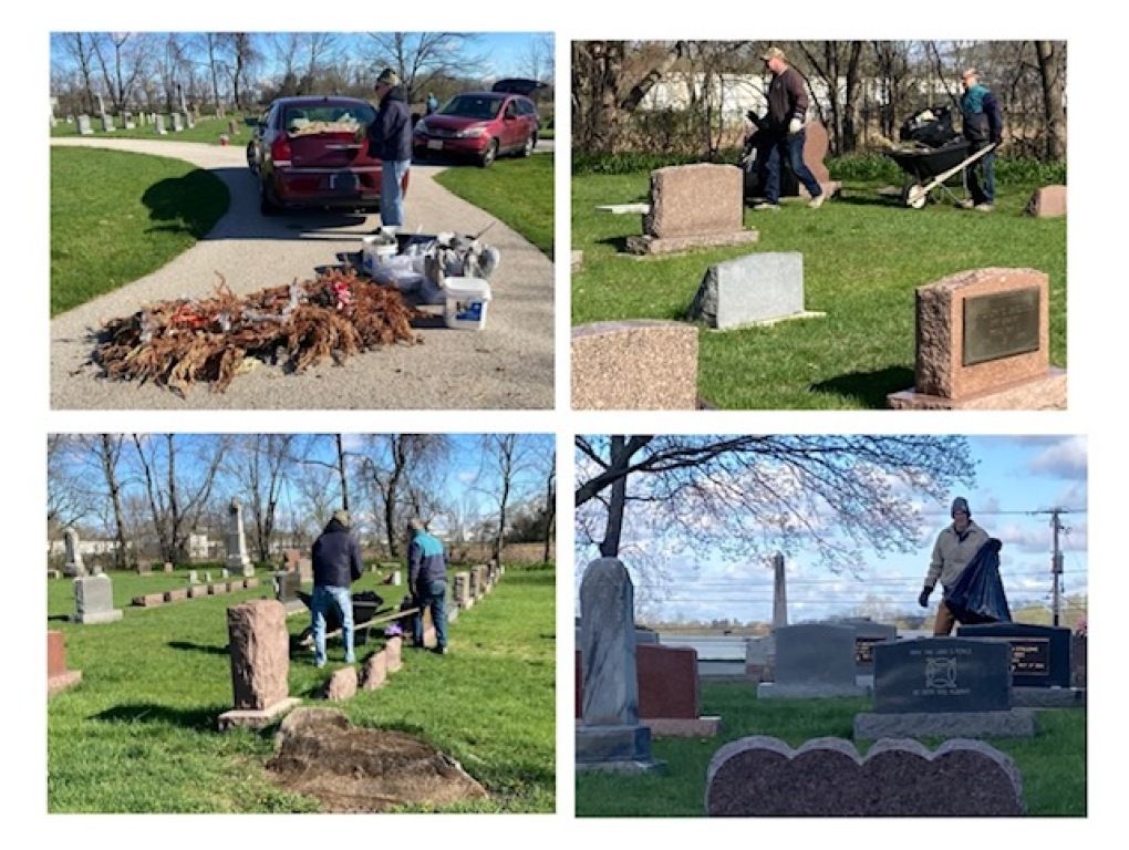 Volunteers setting up and cleaning a cemetery, with headstones, tools, and a pickup truck on a sunny day