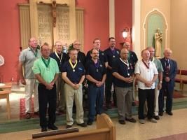 Group of men standing on a church altar in a formal indoor ceremony