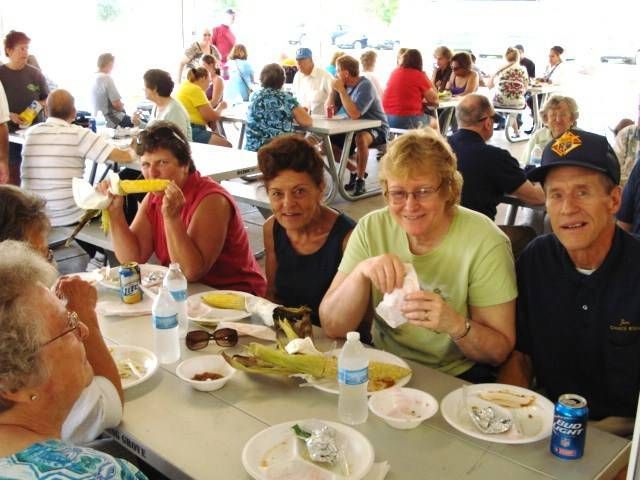 People seated at long tables sharing a meal in a bright community hall