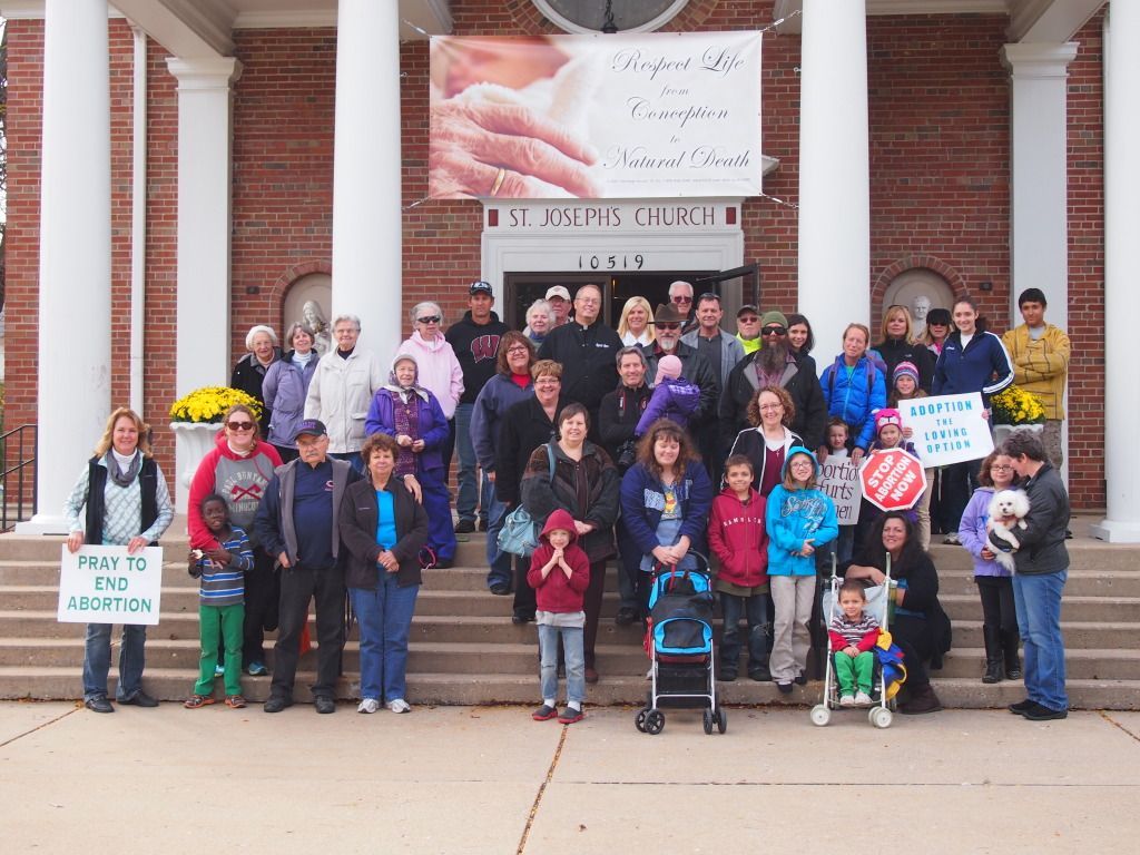 Group of people gathered on courthouse steps holding anti-violence protest signs
