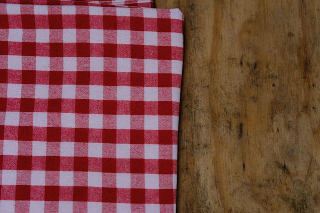 Red-and-white checkered cloth beside a rustic wooden surface