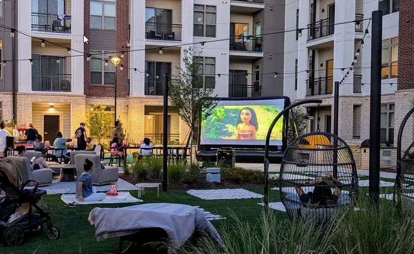A group of people are sitting in front of a large screen watching a movie.