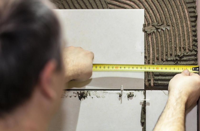 worker measuring the tile