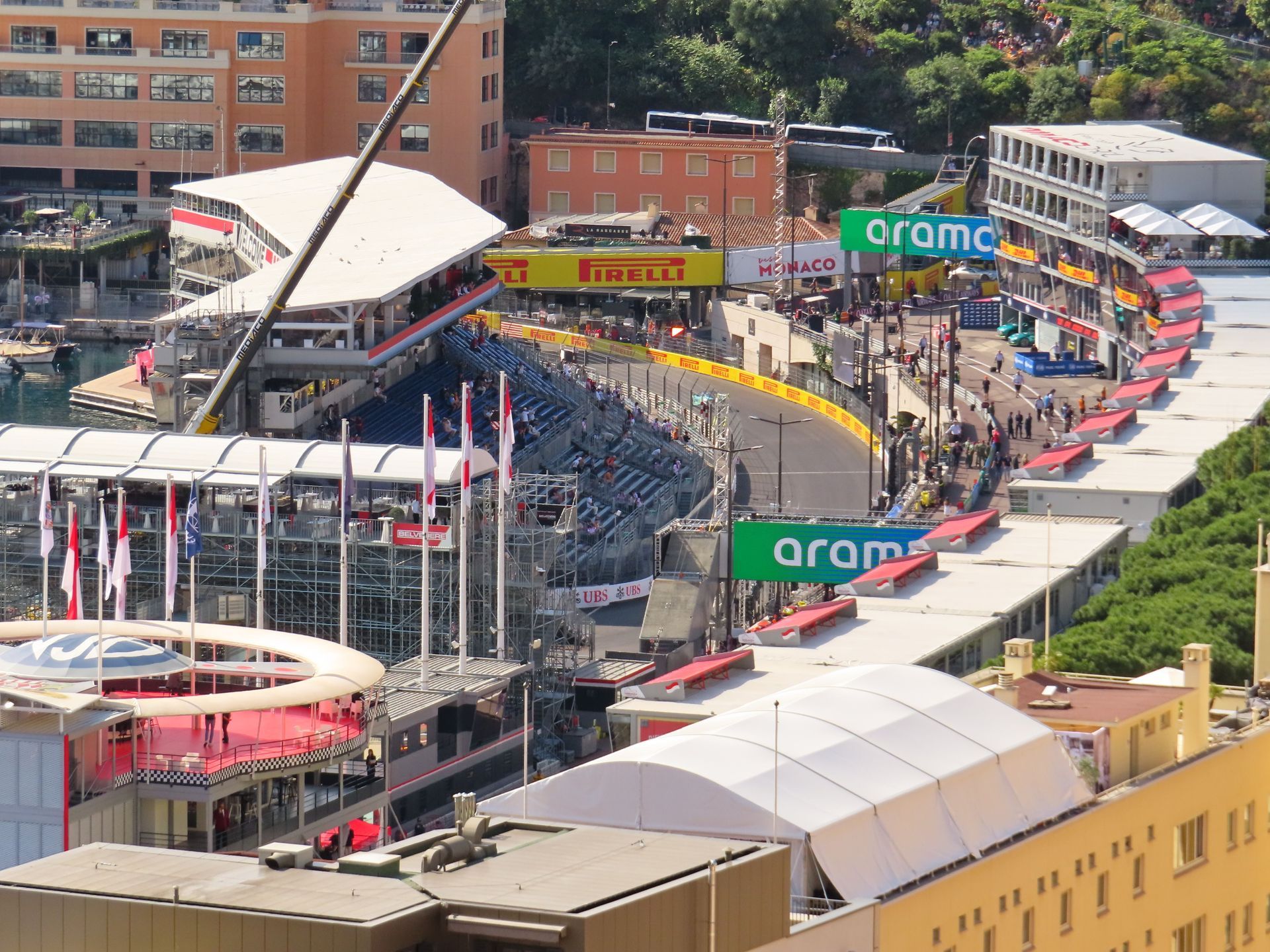 Crowded Formula 1 street circuit with grandstands, barriers, and city buildings along the track