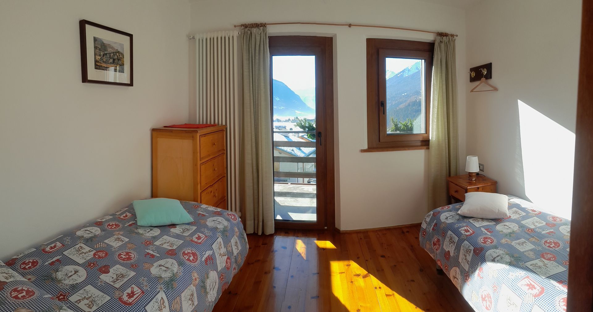 Una camera da letto con due letti, una cassettiera e una finestra.