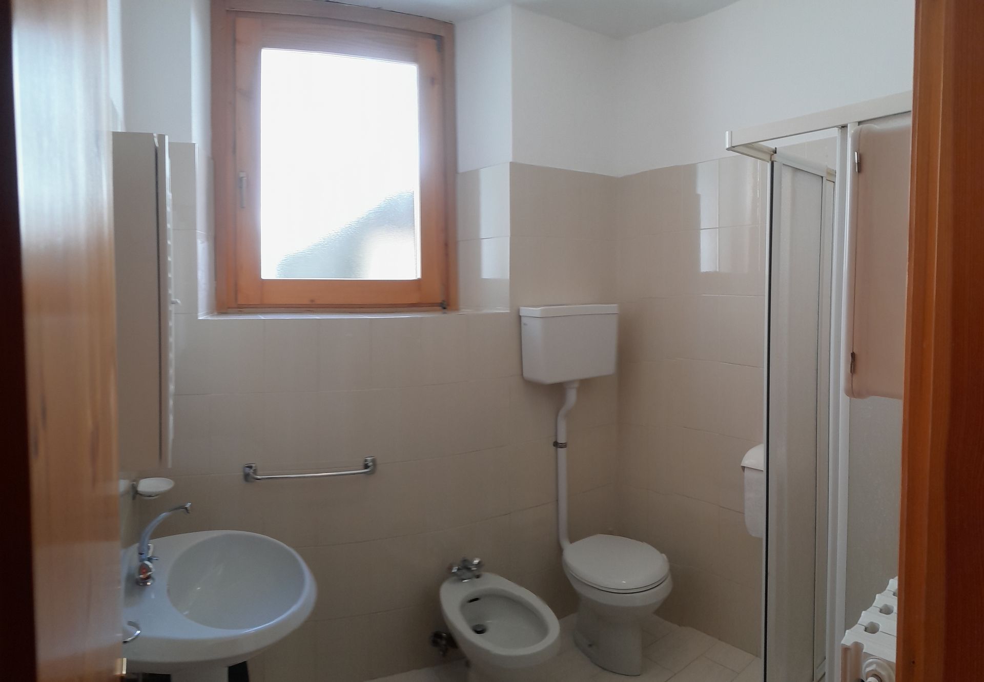 Un bagno con un lavandino, un water e una finestra