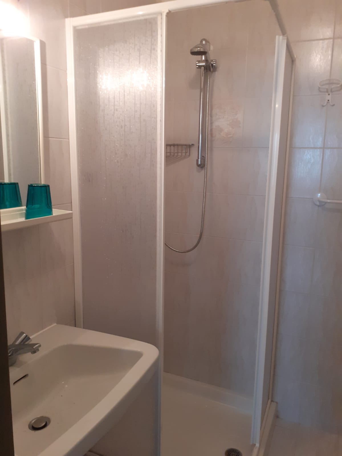 Un bagno con lavandino, doccia e specchio.