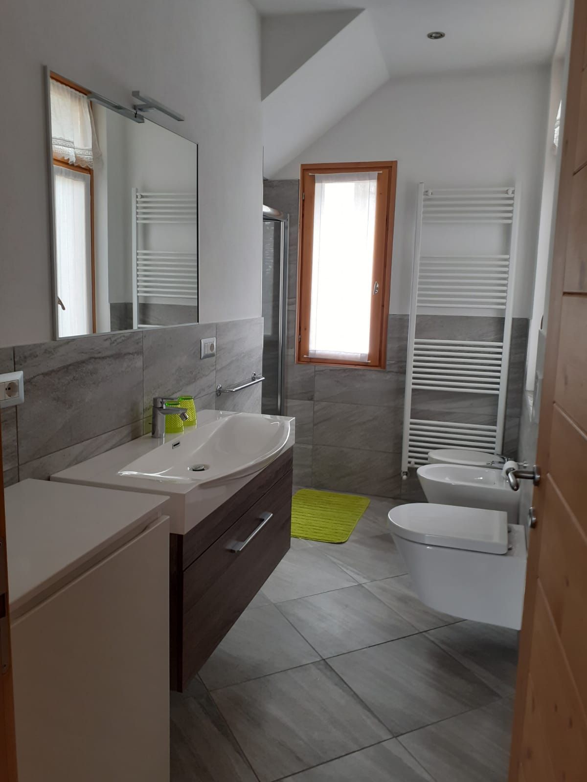 Un bagno con lavandino, water e specchio.
