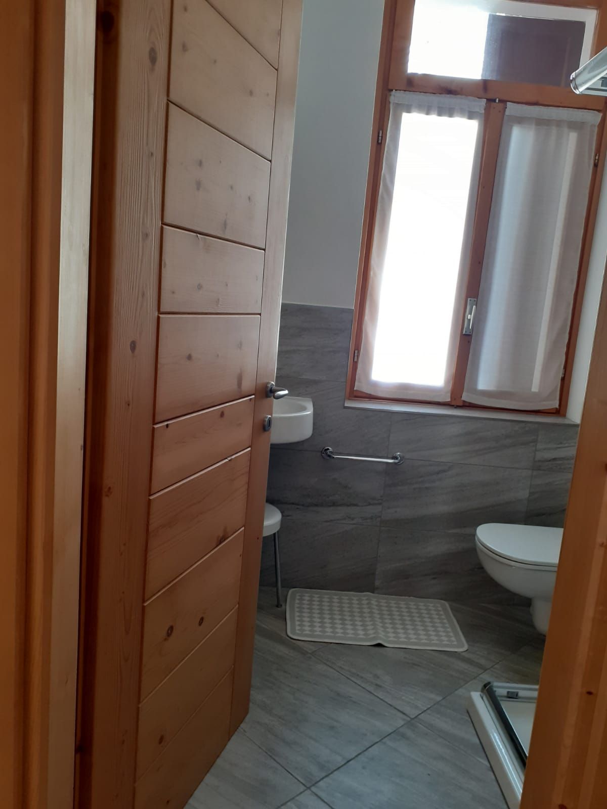 Un bagno con lavandino, water e finestra.