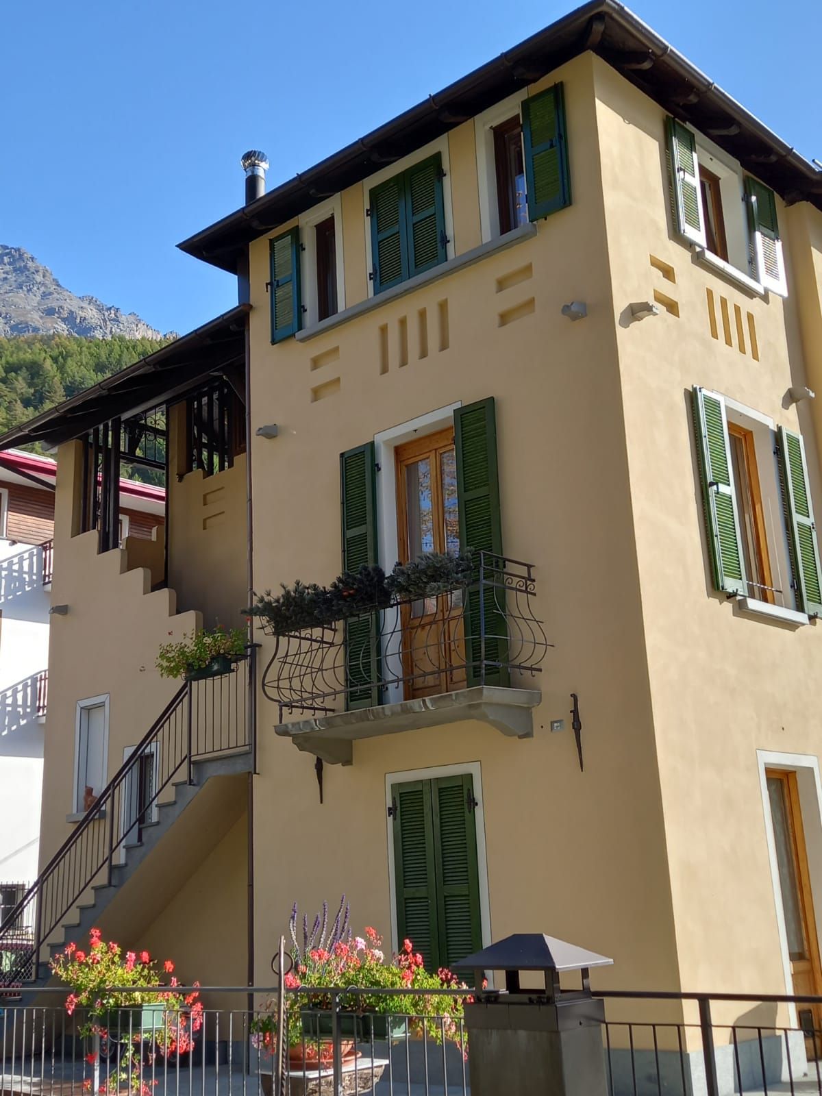 Un edificio giallo con persiane e scale verdi