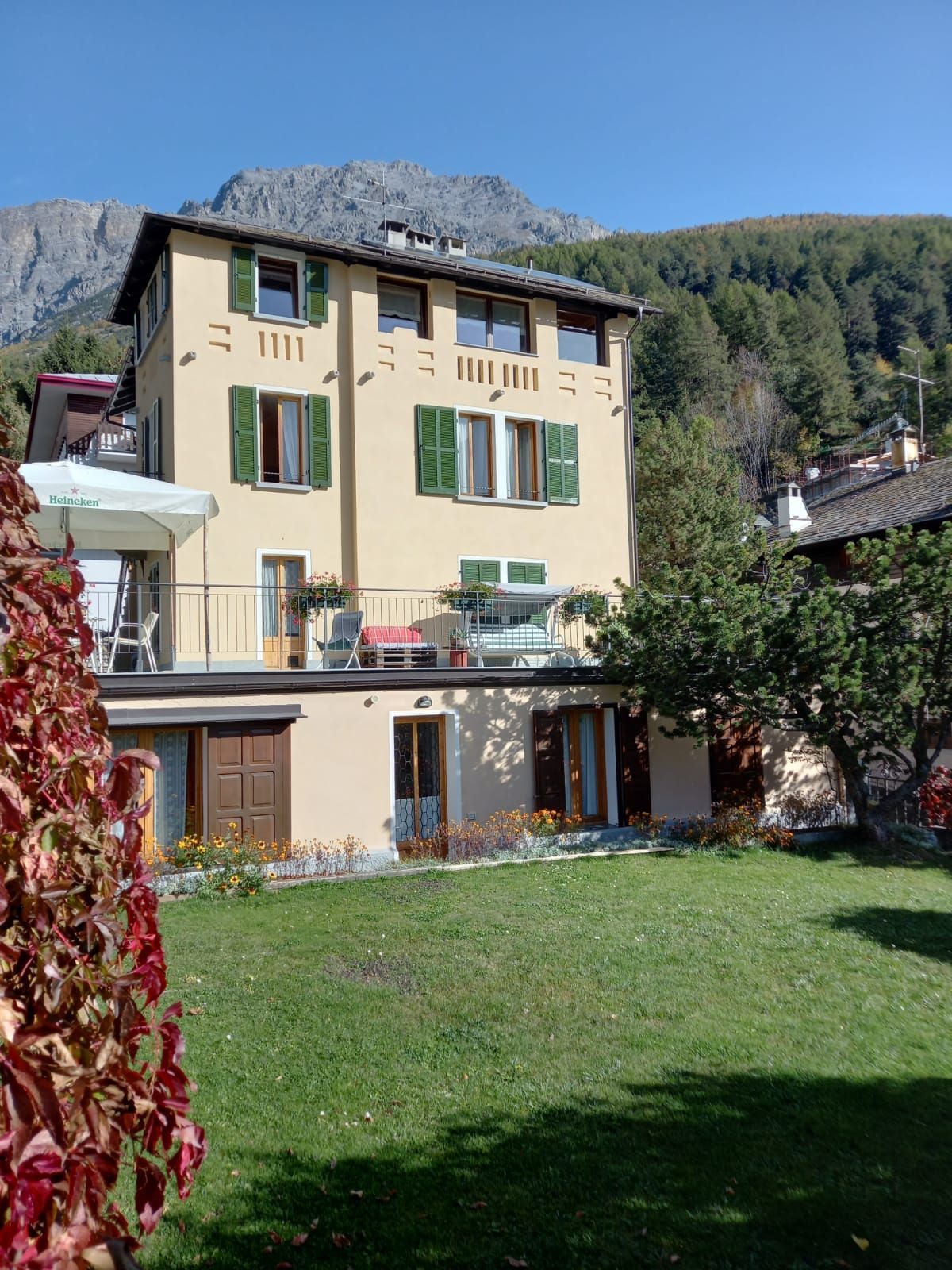 Una grande casa gialla con persiane verdi alle finestre