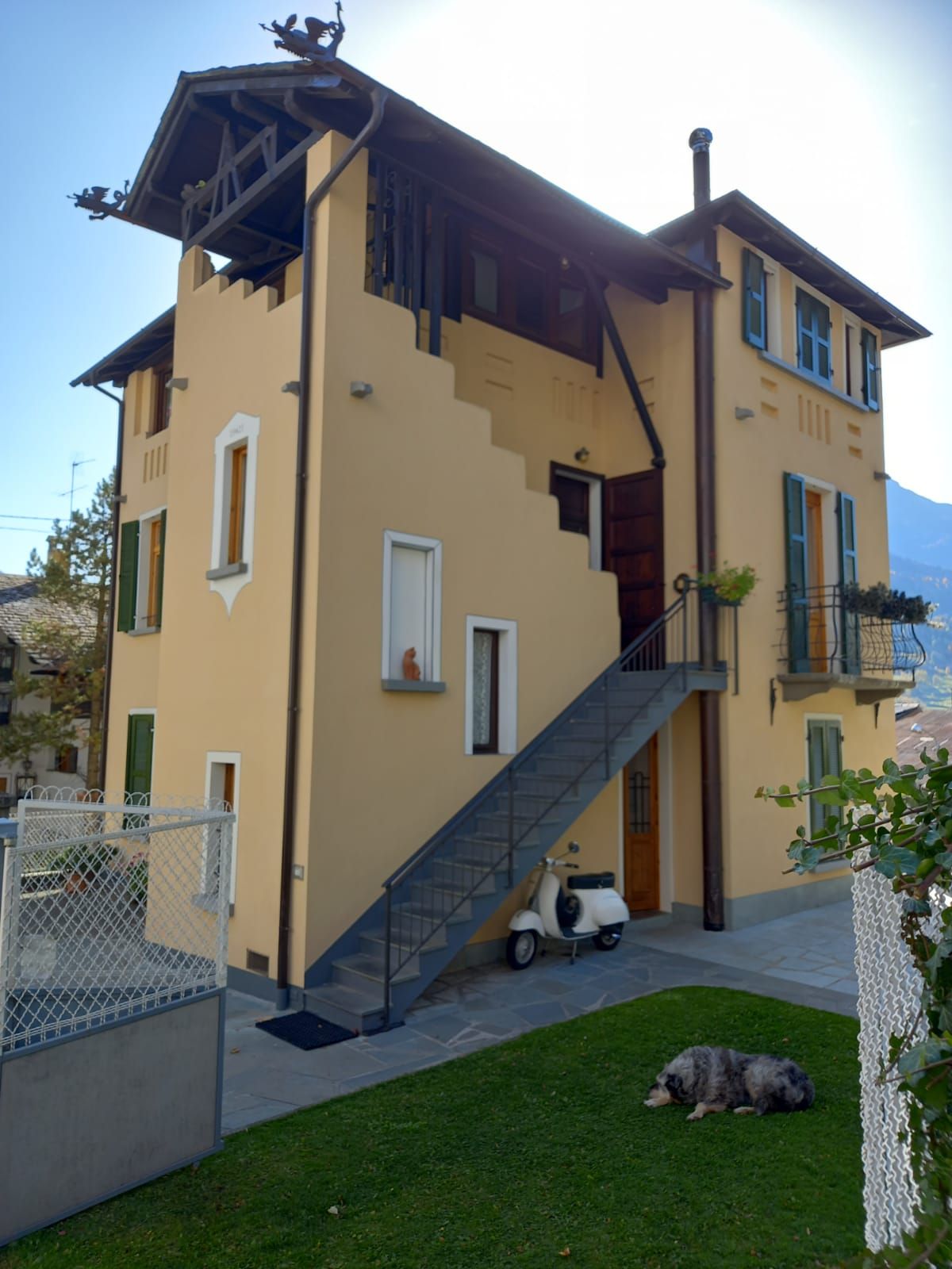 Un edificio giallo con persiane e scale verdi