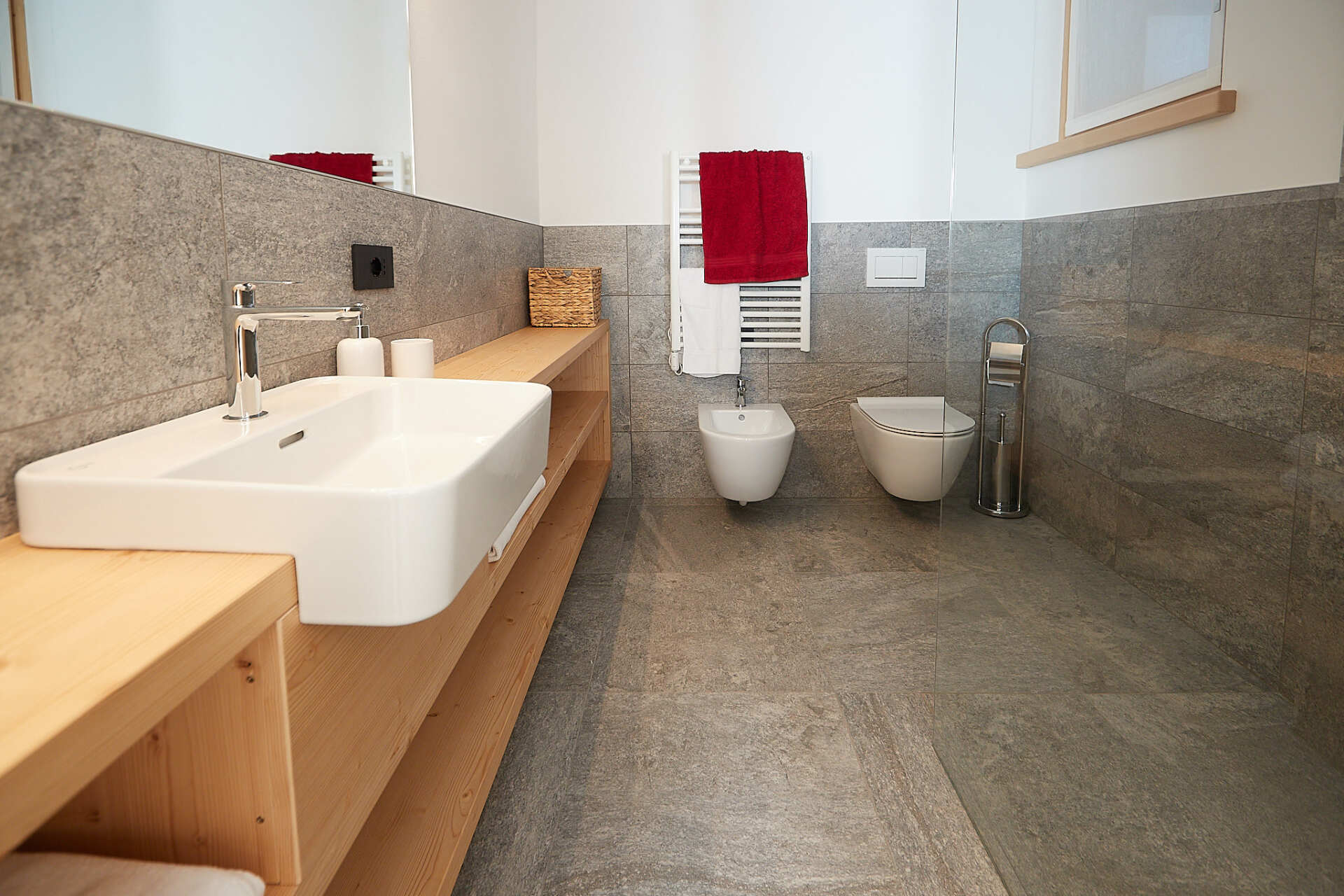 Un bagno con due wc, un lavandino e uno specchio