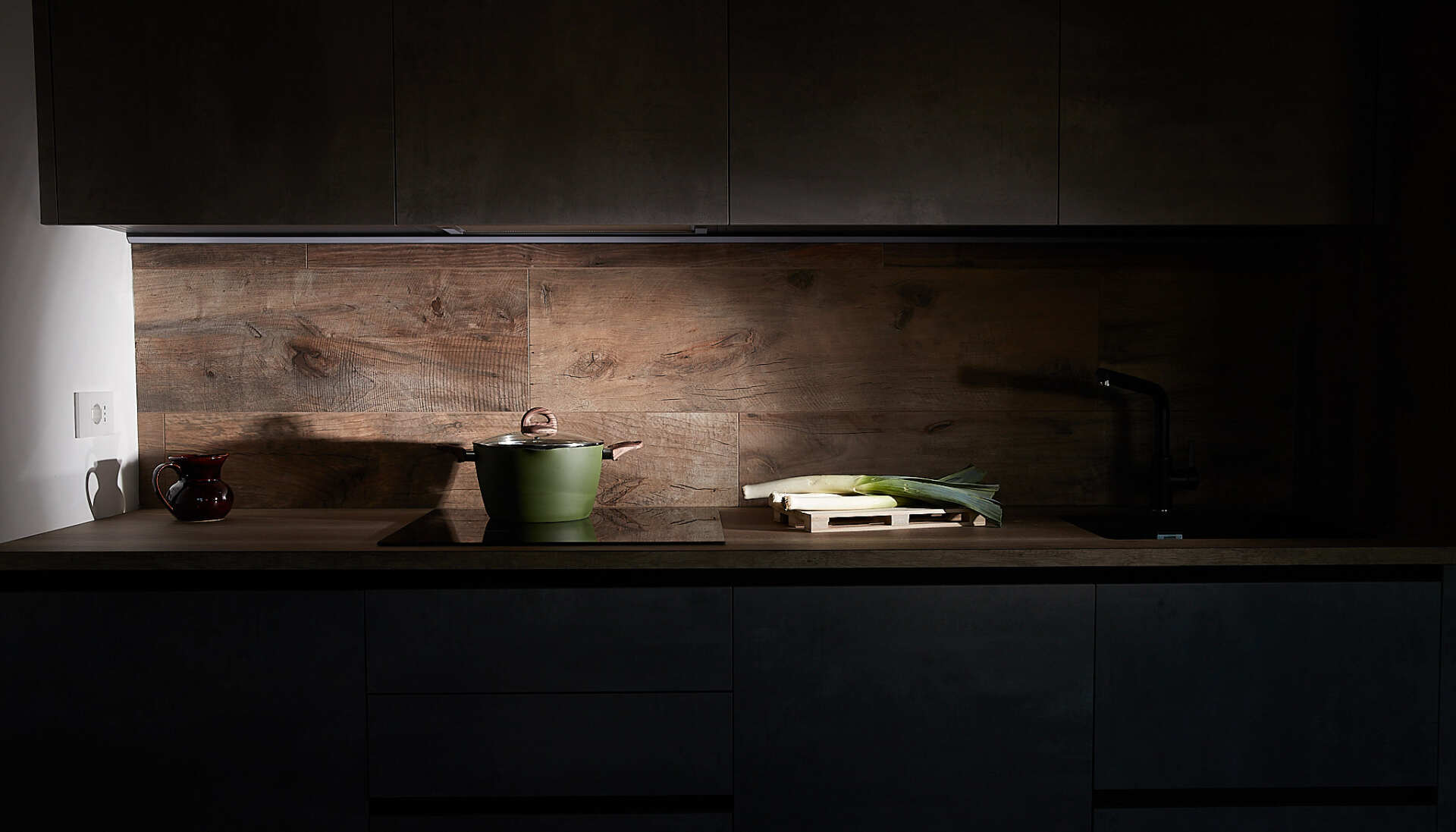Una cucina con una pentola e un tagliere sul tavolo.
