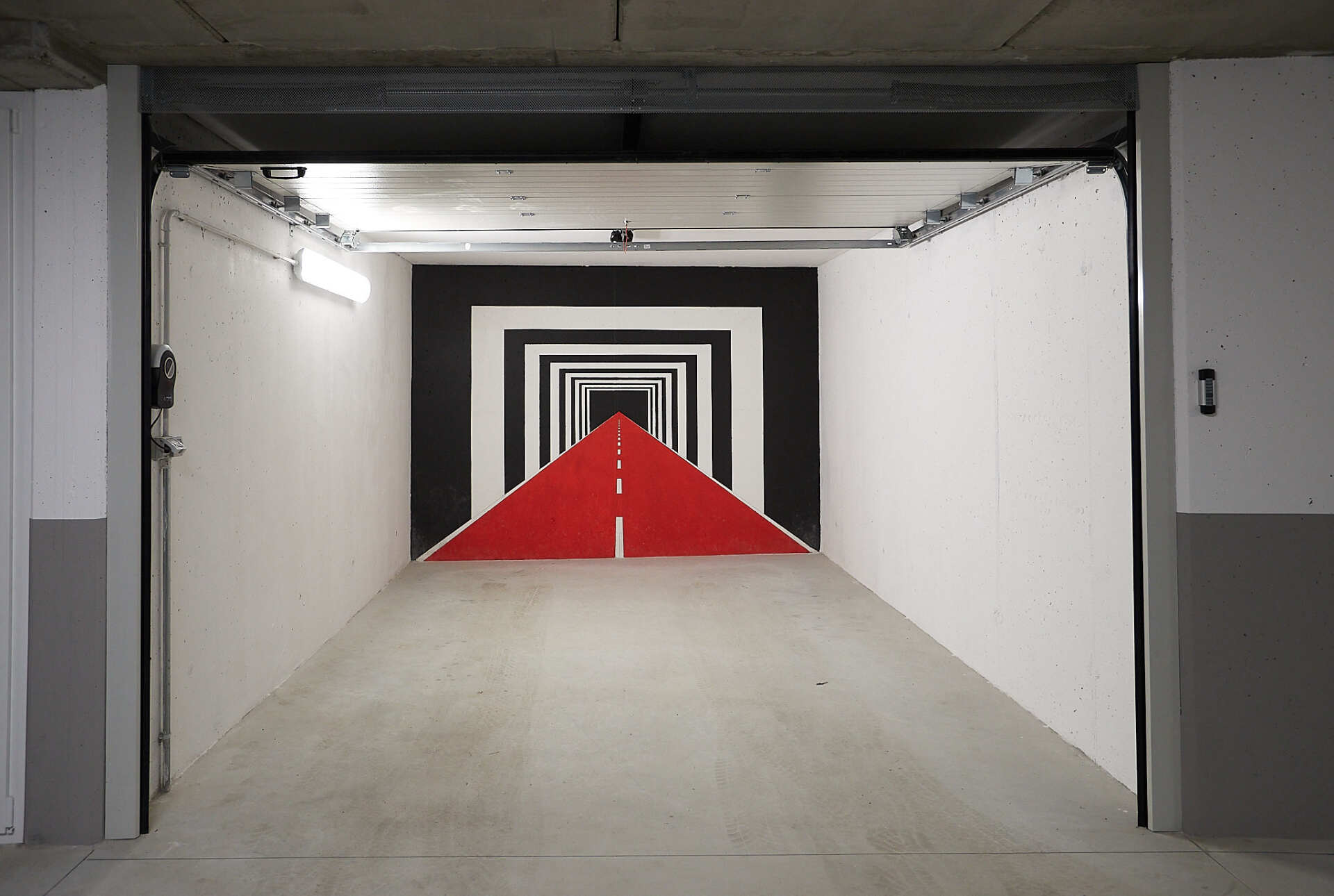 Un garage con una strada rossa dipinta sul muro