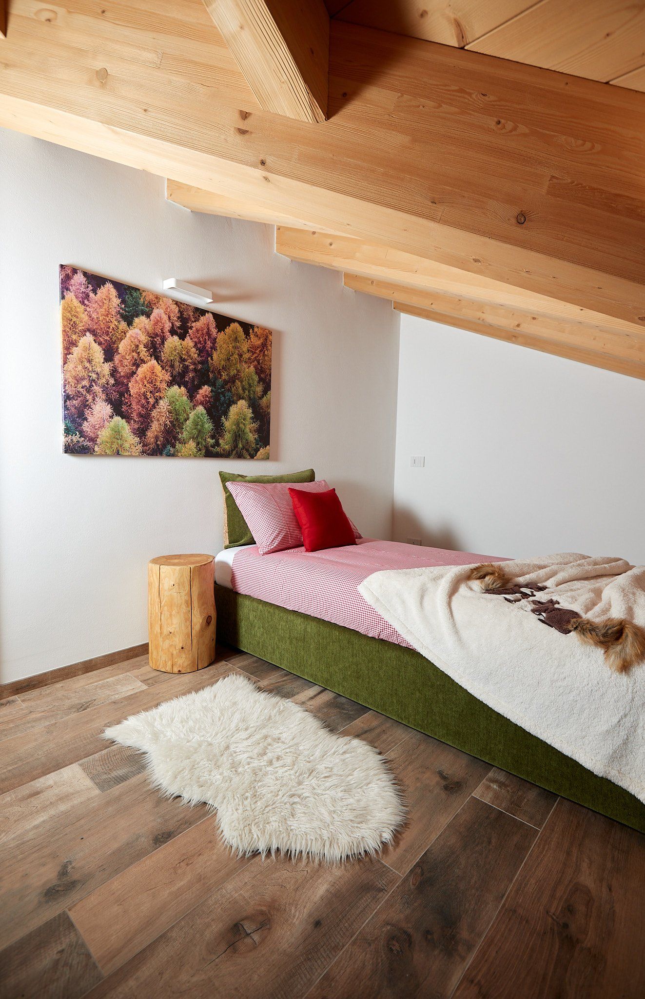Una camera da letto con un letto singolo e un quadro alla parete.