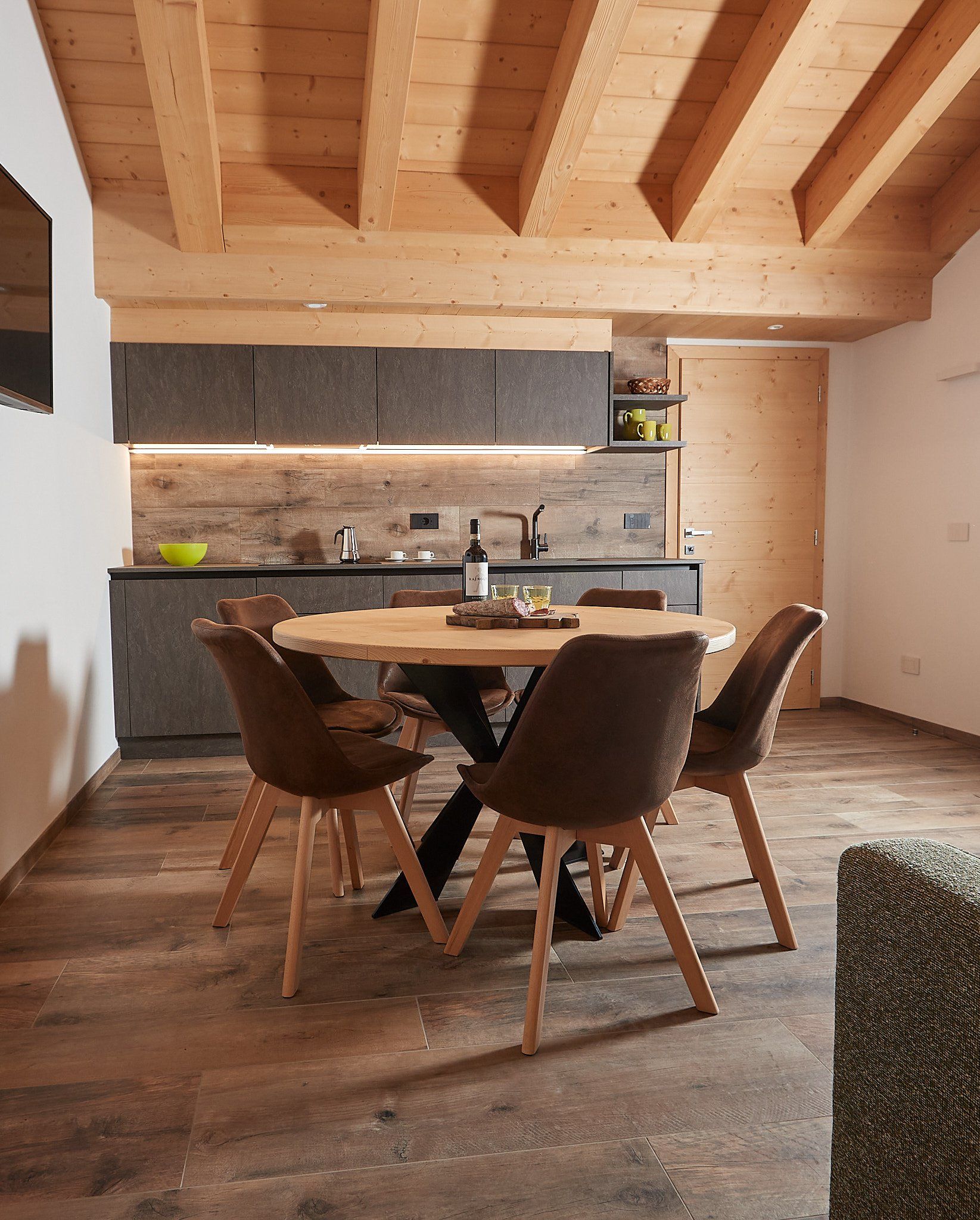 Una sala da pranzo con tavolo e sedie di fronte alla cucina.
