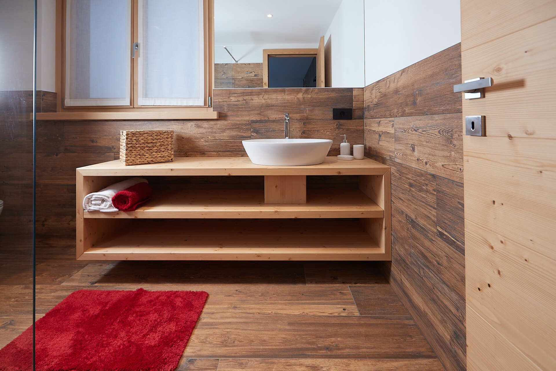 Un bagno con un lavandino e un tappeto rosso