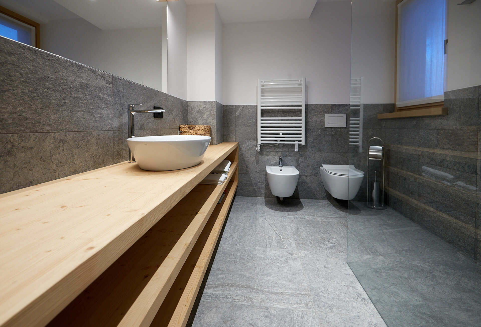 Un bagno con lavandino, wc, bidet e doccia.