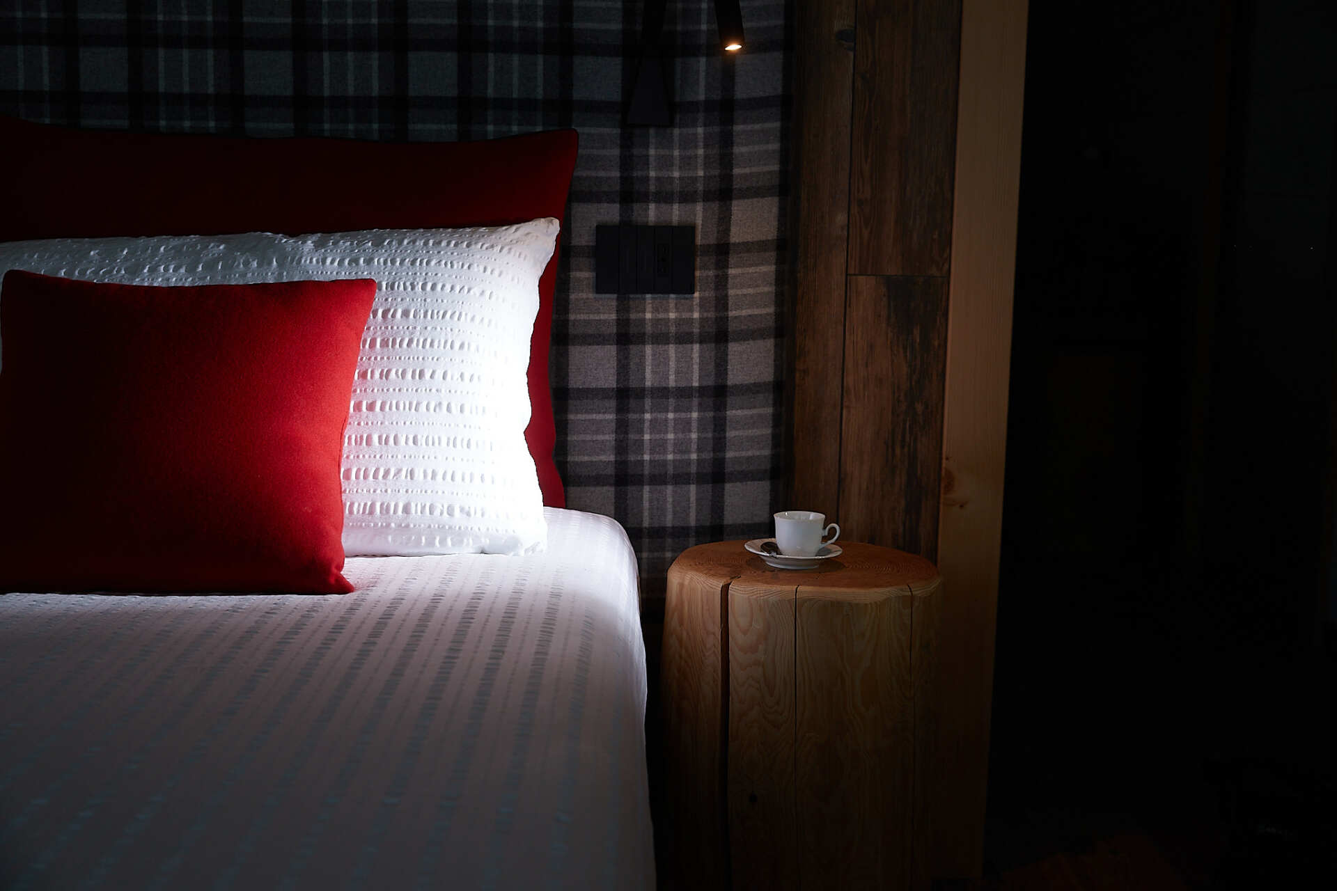 Una camera da letto con un letto e un comodino con una tazza di caffè sopra