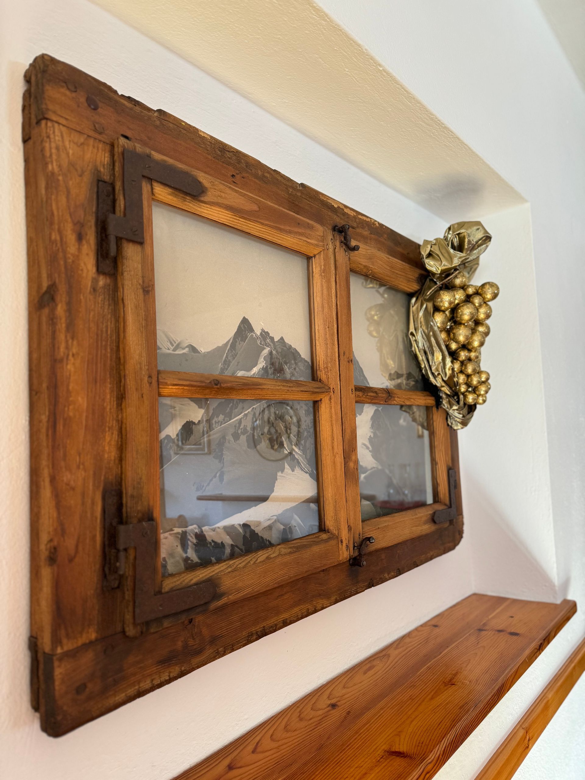 Una finestra di legno con un disegno di montagne sopra