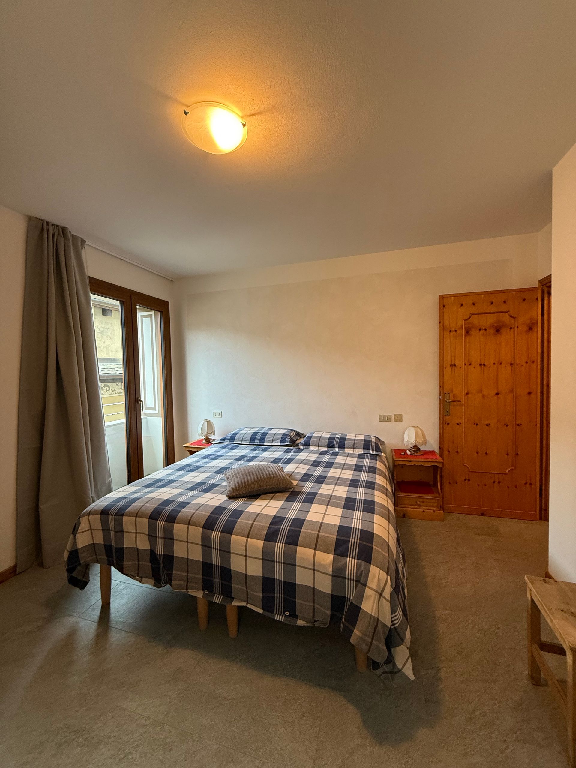 Una camera da letto con un letto grande e una porta di legno