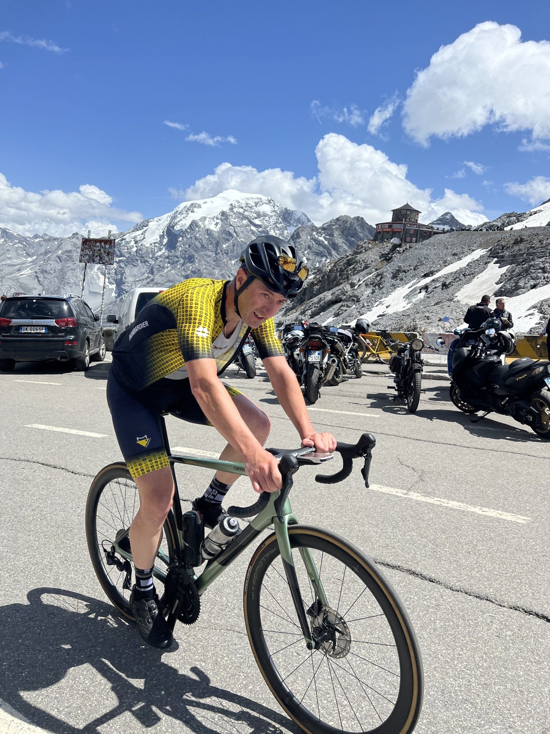 Un uomo sta andando in bicicletta su una strada di fronte a una montagna.
