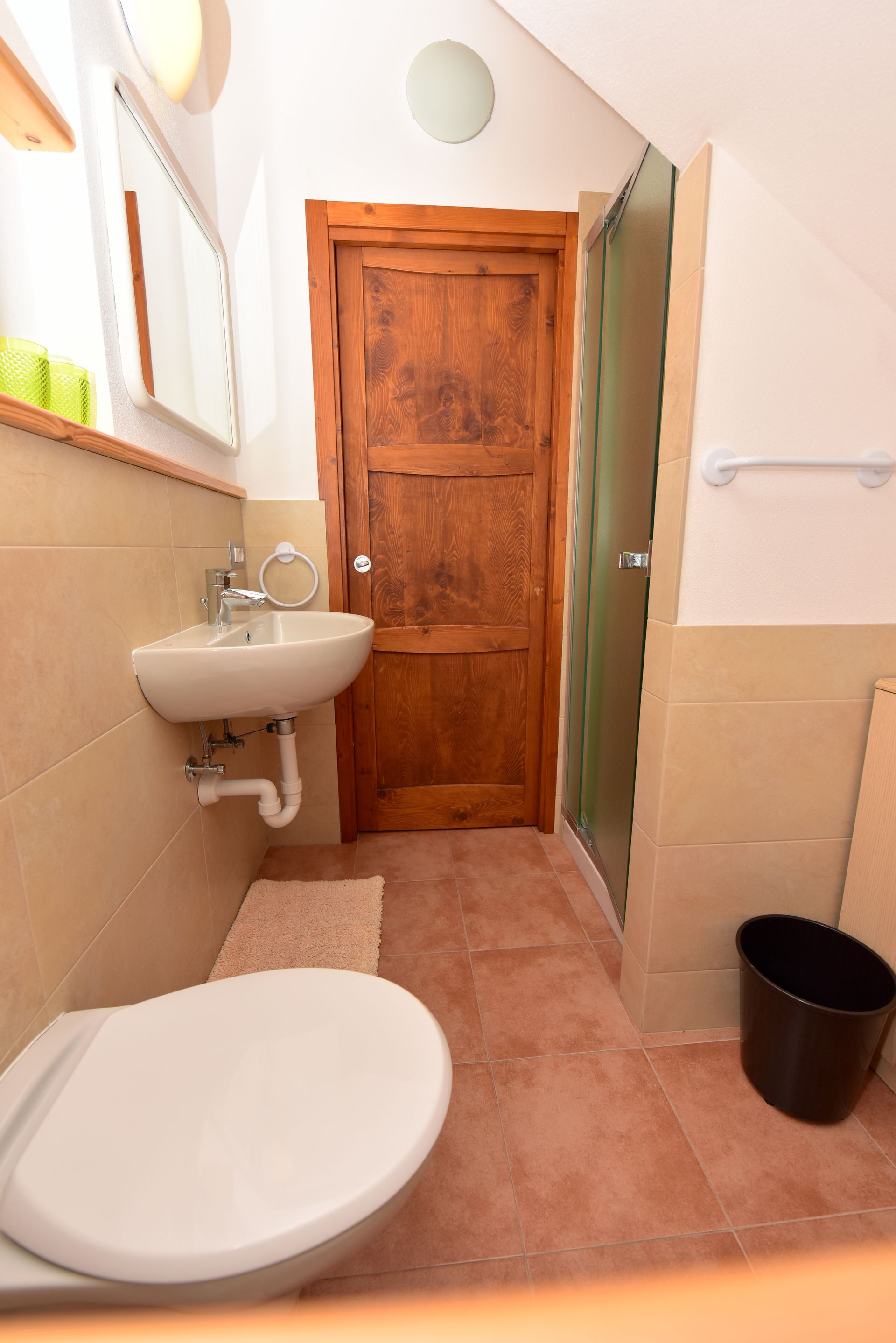Un bagno con wc, lavandino e specchio.