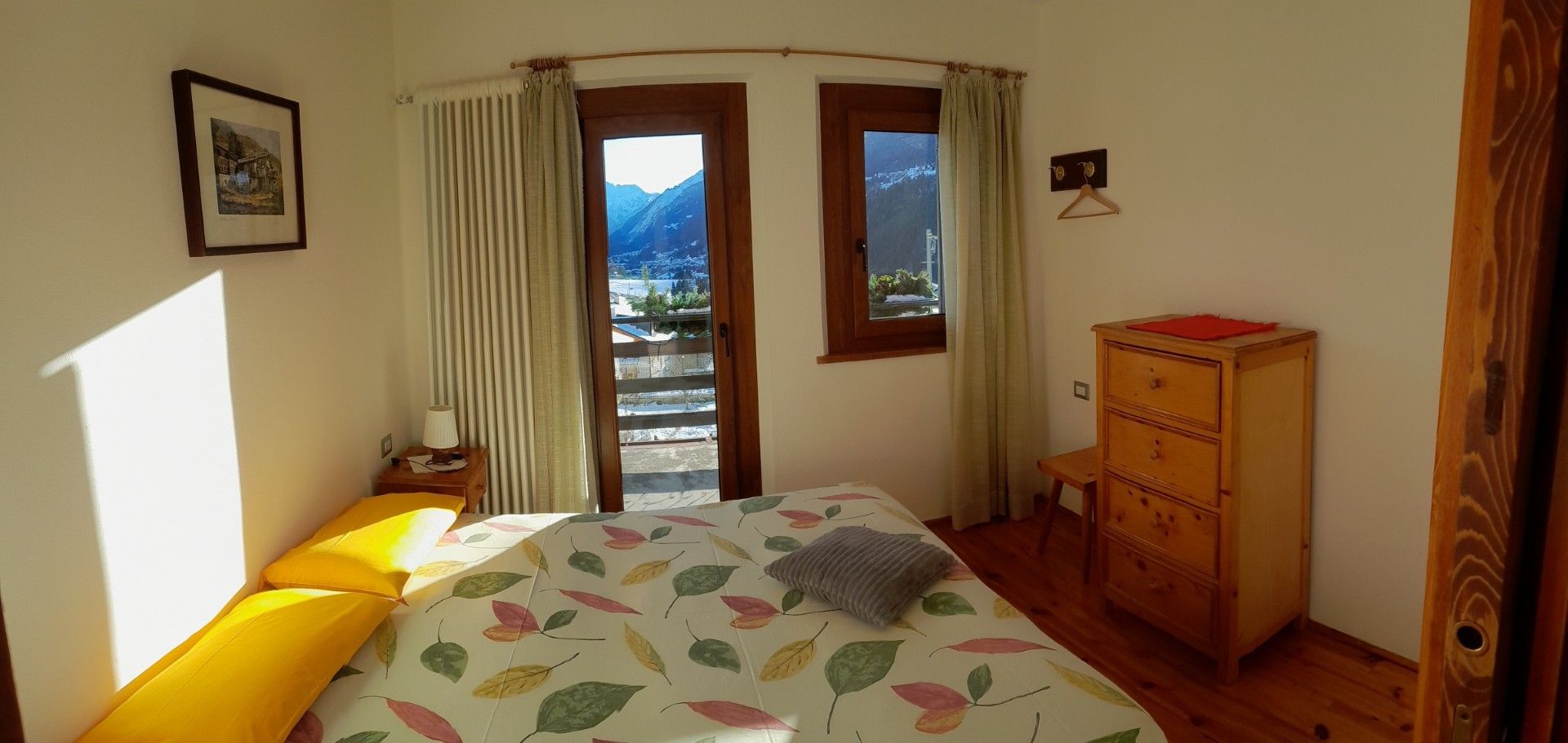 Una camera da letto con un letto, una cassettiera e una finestra.