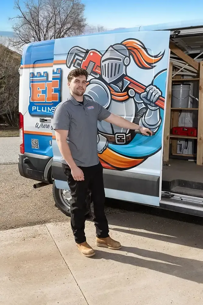 Empire Plumbing service technician beside a branded blue van