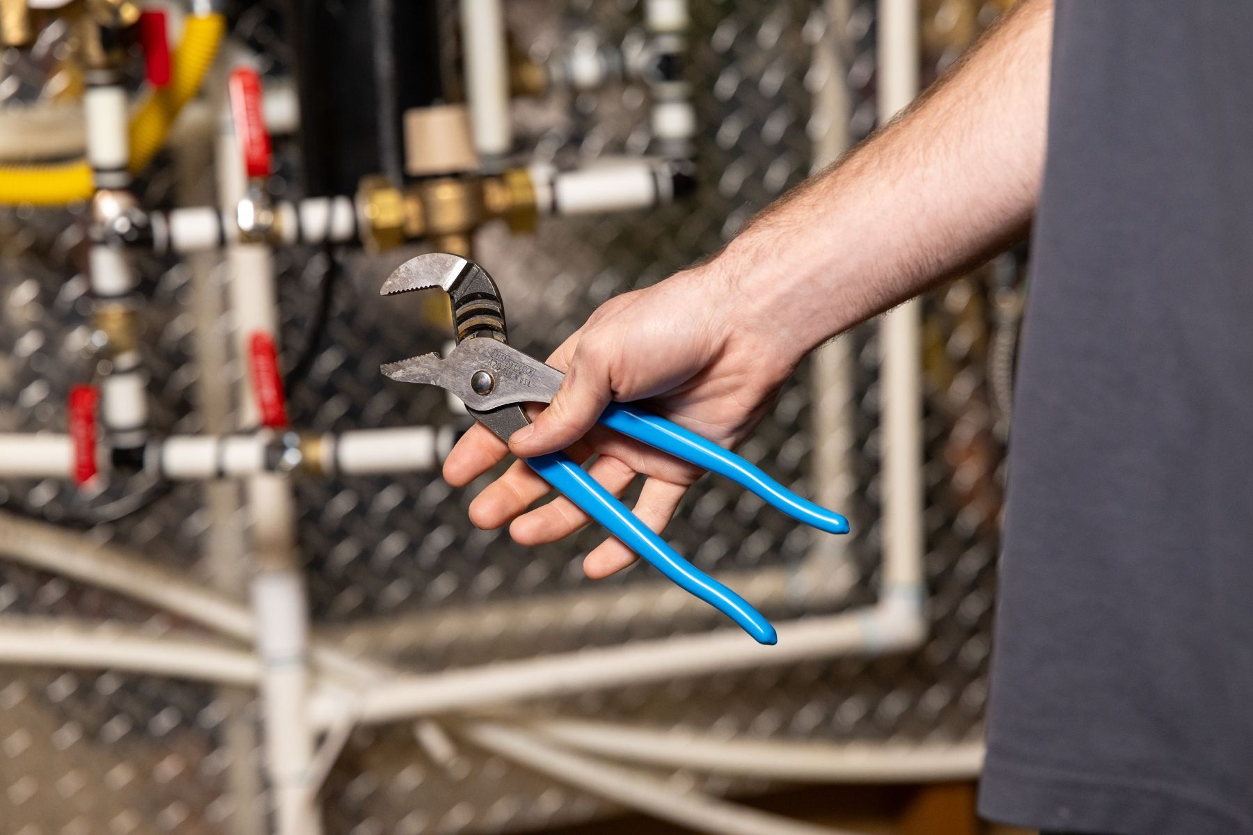 Three technicians reviewing a clipboard beside industrial pipes and filtration equipment Three technicians reviewing a clipboard beside industrial pipes and filtration equipment