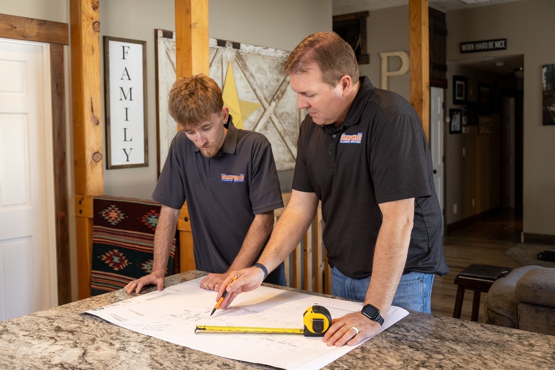 Three technicians reviewing a clipboard beside industrial pipes and filtration equipment