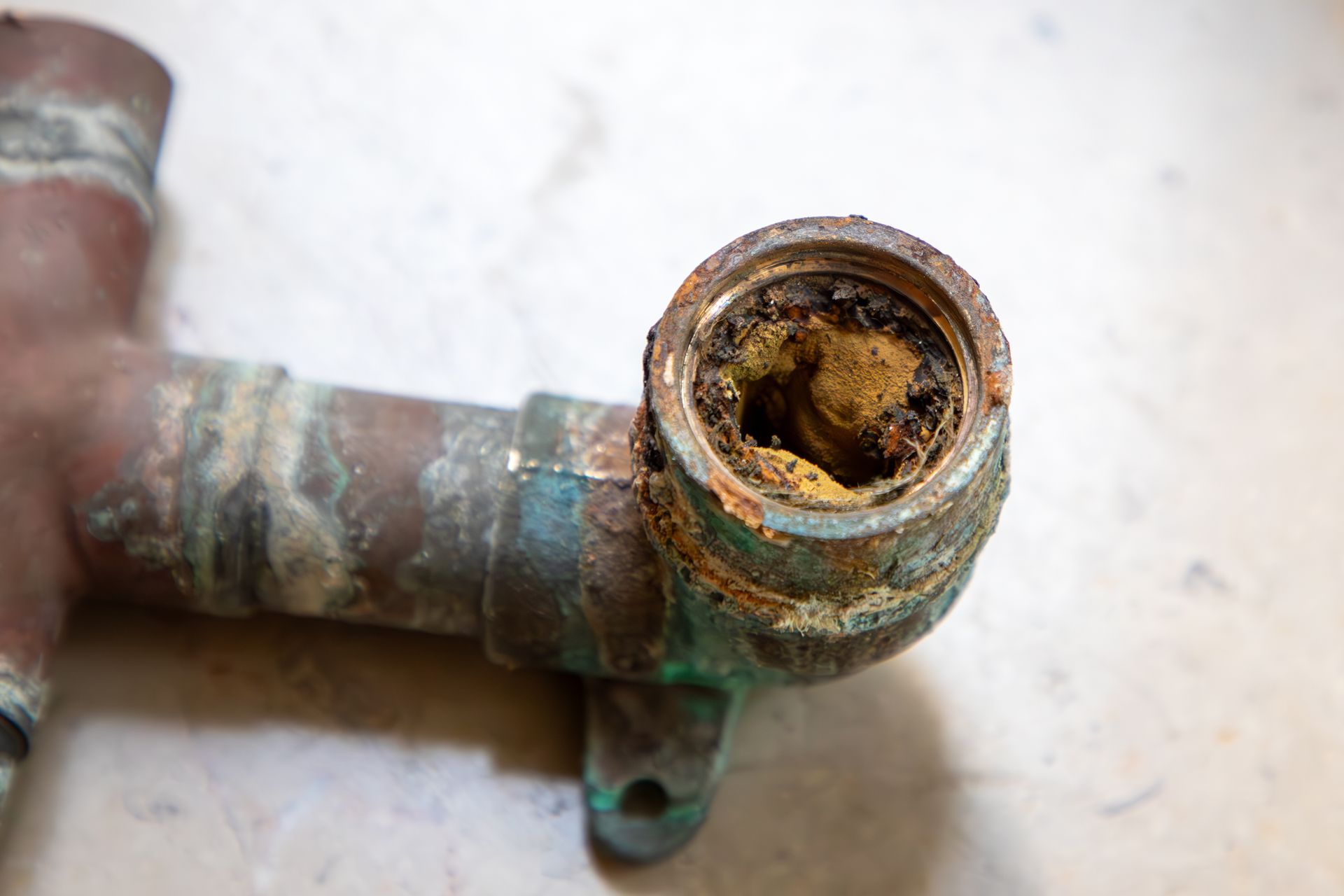 Corroded copper pipe fitting with mineral buildup inside