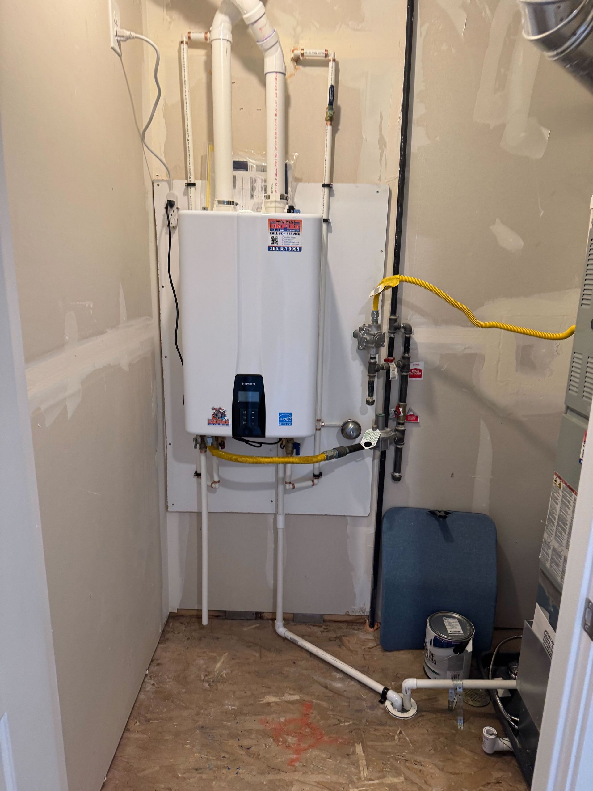 Wall-mounted Navien tankless water heater with gas line, PVC venting and service valves