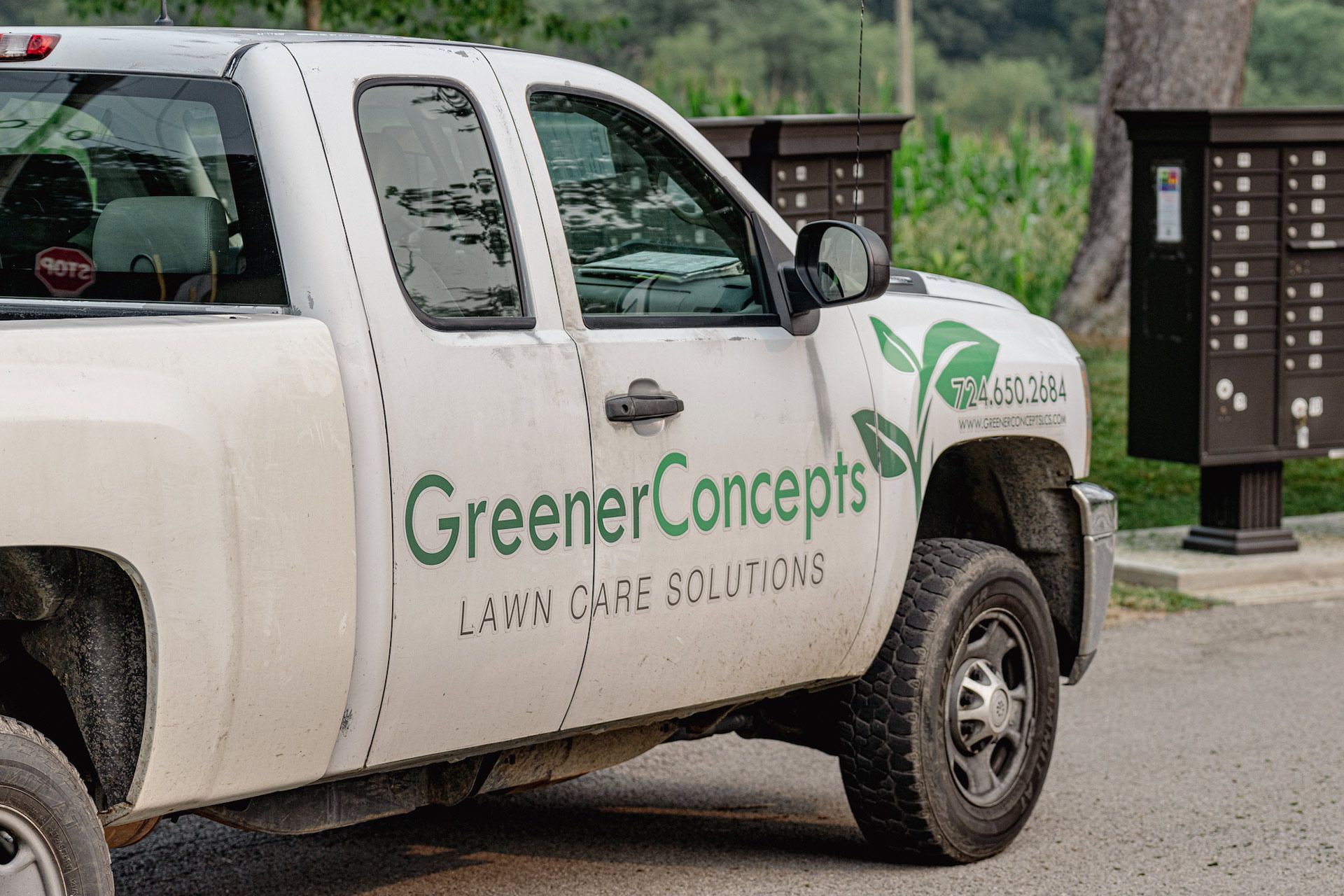 White Greener Concepts lawn care pickup truck parked outdoors