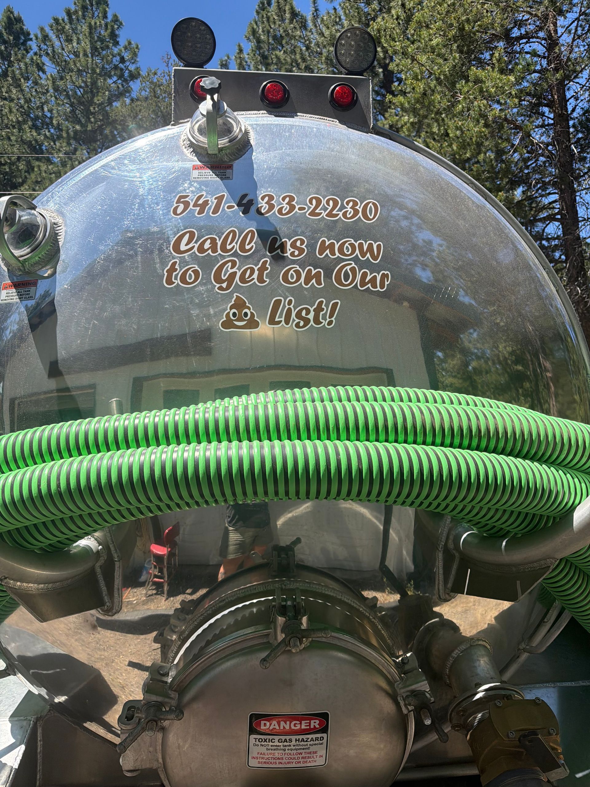 Fire truck front with chrome dome, green hose, and gold lettering in an outdoor setting Fire truck front with chrome dome, green hose, and gold lettering in an outdoor setting