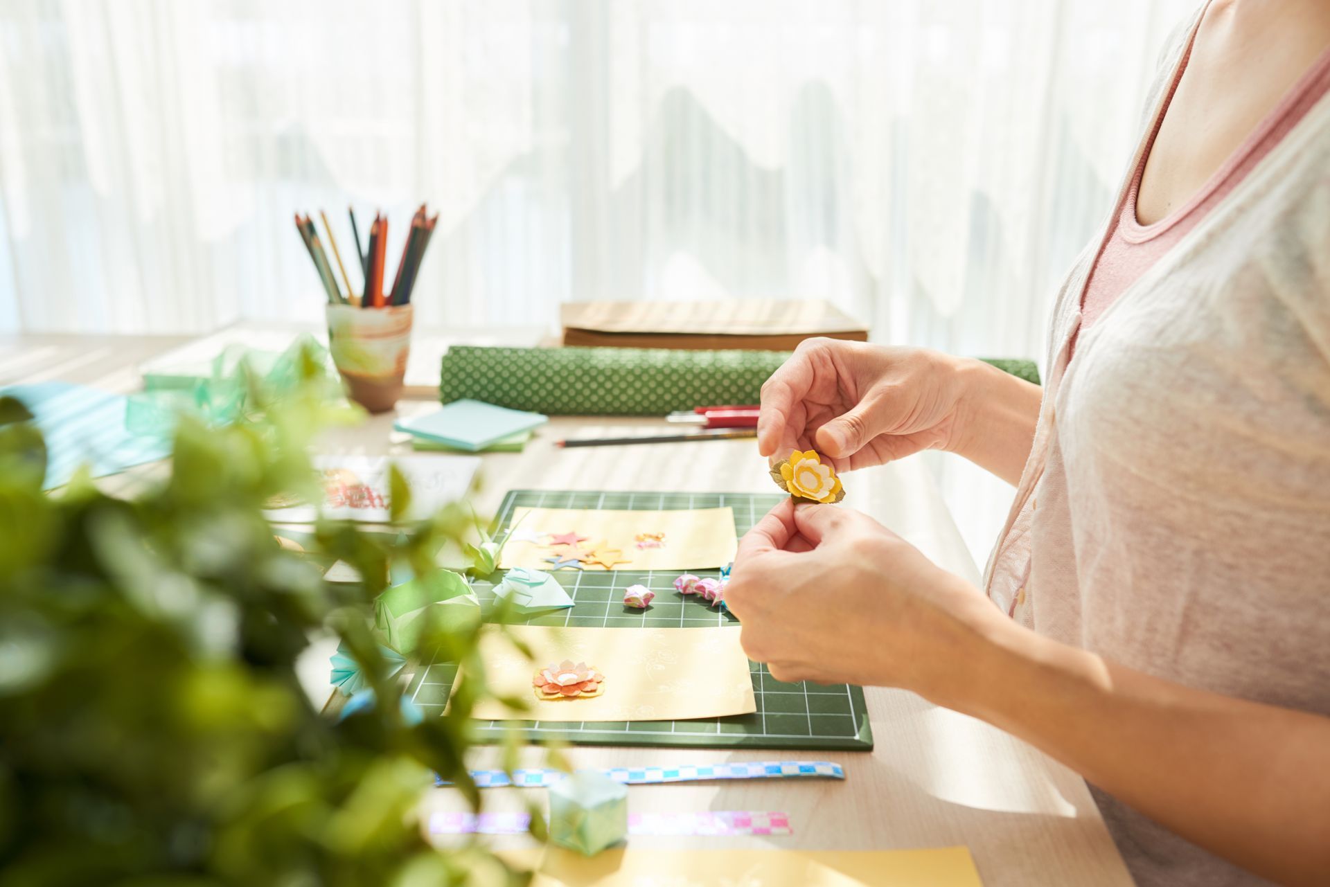 A woman is sitting at a table making crafts.
