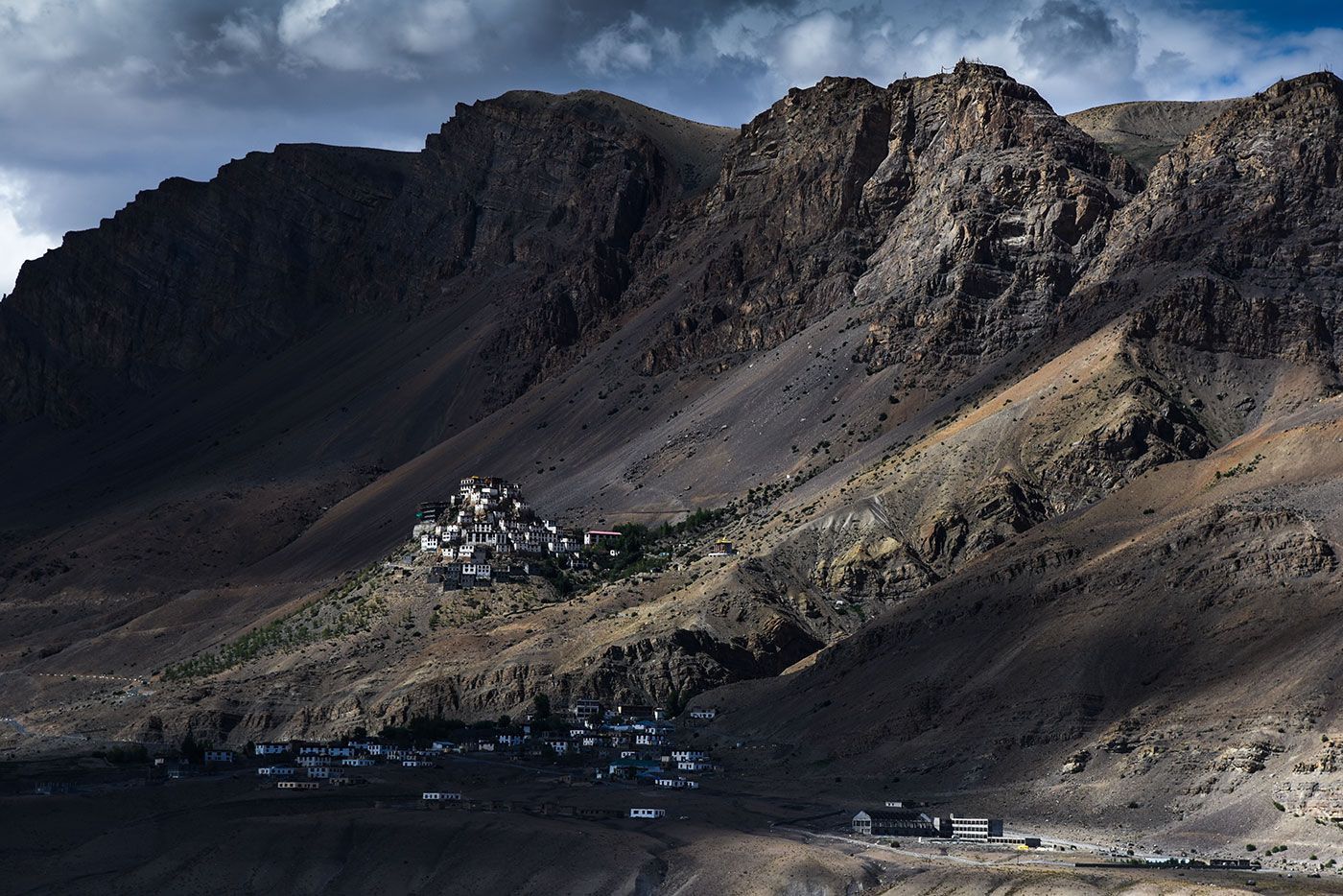 Confluence of Indus and Zanskar rivers in Ladakh, India; brown and green waters meet, mountains in background, prayer flags in foreground.