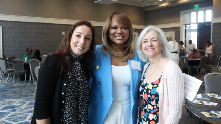 Three women are posing for a picture together in a room.