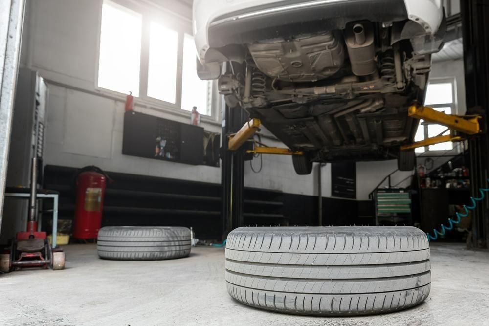 A Car On a Lift With A Tire On The Ground — Mechanic in Lismore, NSW