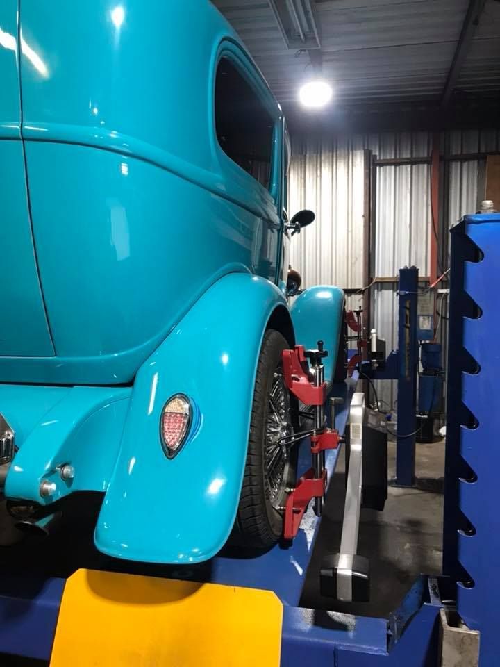 A Blue Car Is Sitting On A Lift In A Garage — Mechanic in Lismore, NSW